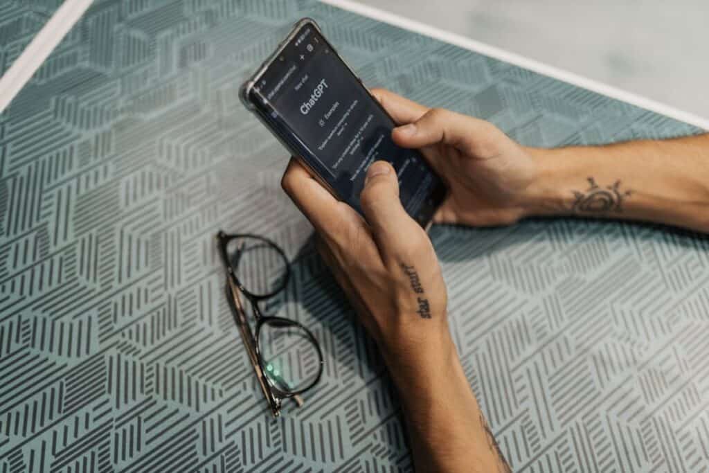 Nahaufnahme der Hand eines Mannes, der ChatGPT auf seinem Mobiltelefon benutzt