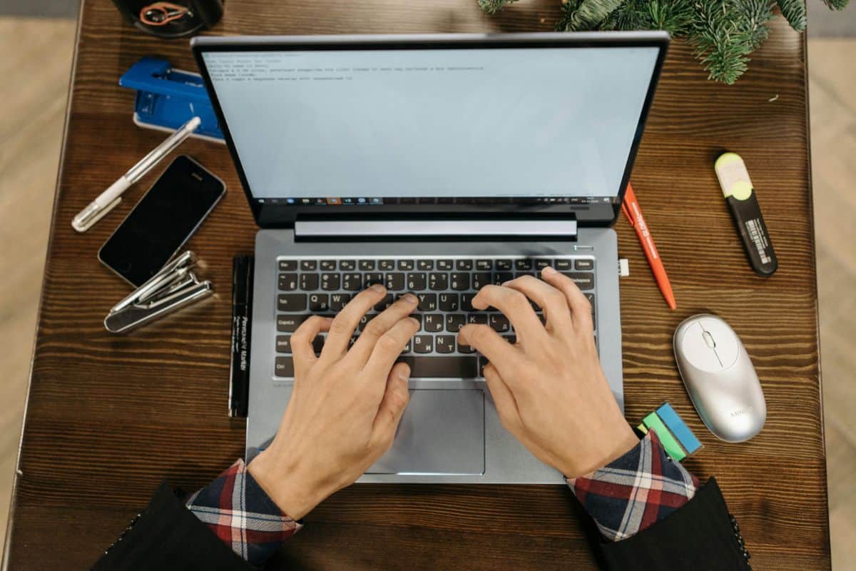Hands typing on a laptop keyboard