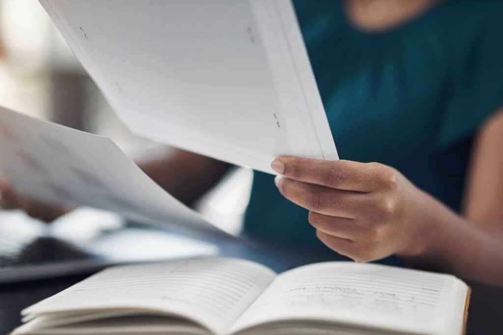 ¿Qué extensión debe tener un enunciado de tesis? Consejos y ejemplos 4 Woman hands and review paper in office proofreading and editing pages