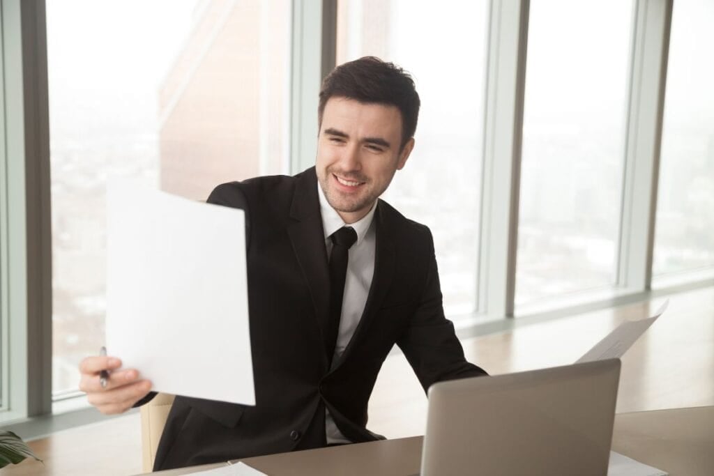 
Happy businessman holding financial statistics report,