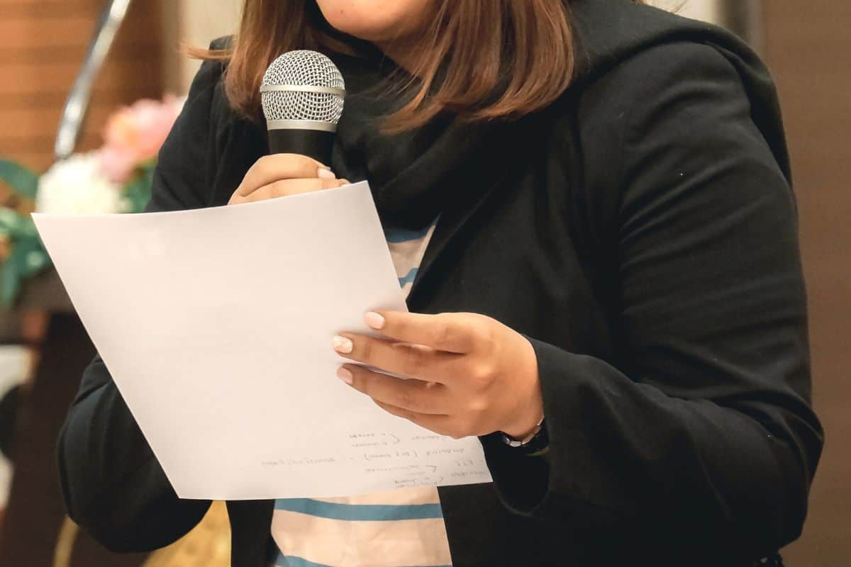 Midsection of woman holding microphone
