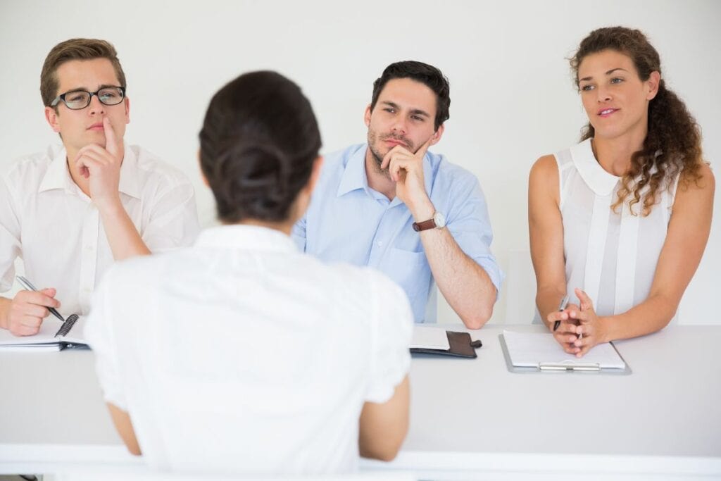 Woman being interviewed by business people