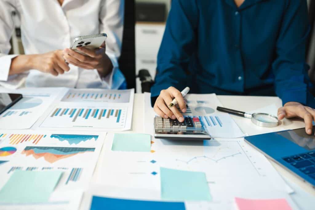 Business team working on desk office with using a calculator to calculate