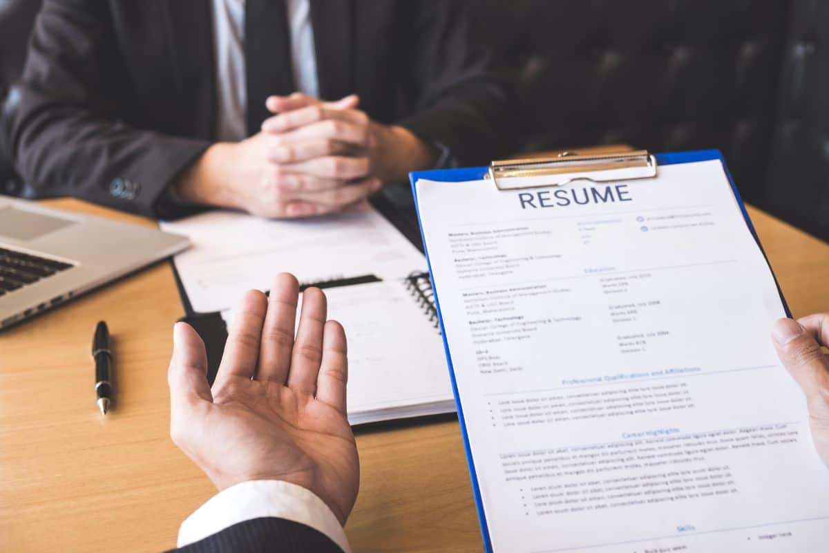 Cropped hands of employer interviewing man in office