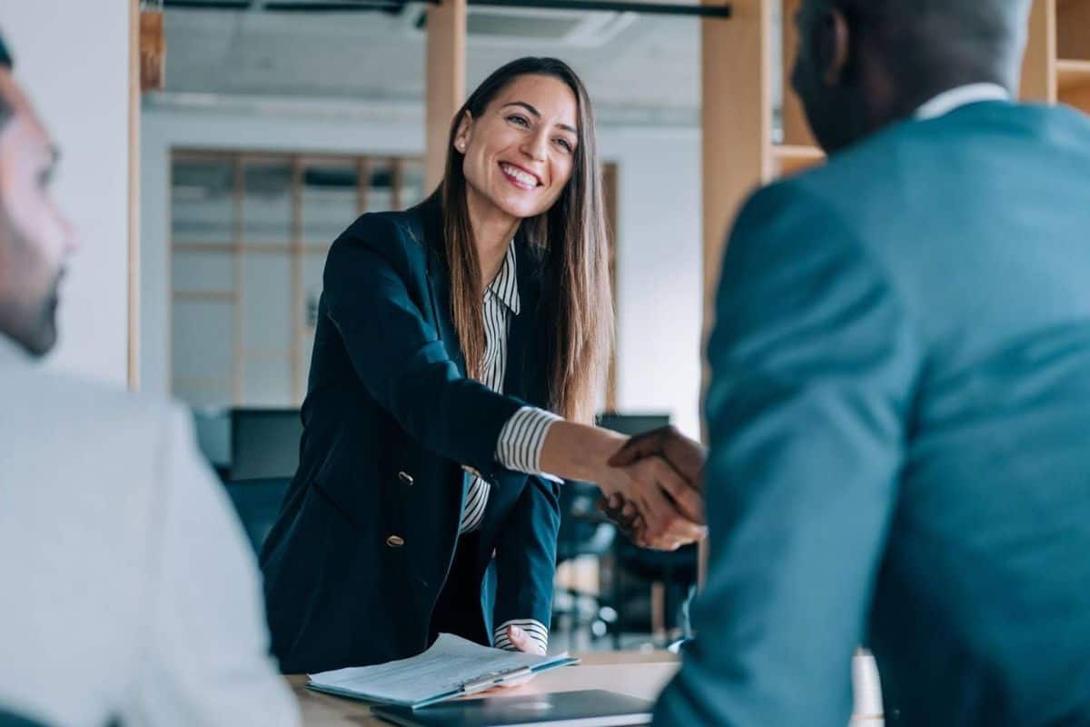 Woman and manager shaking hands in a professional setting