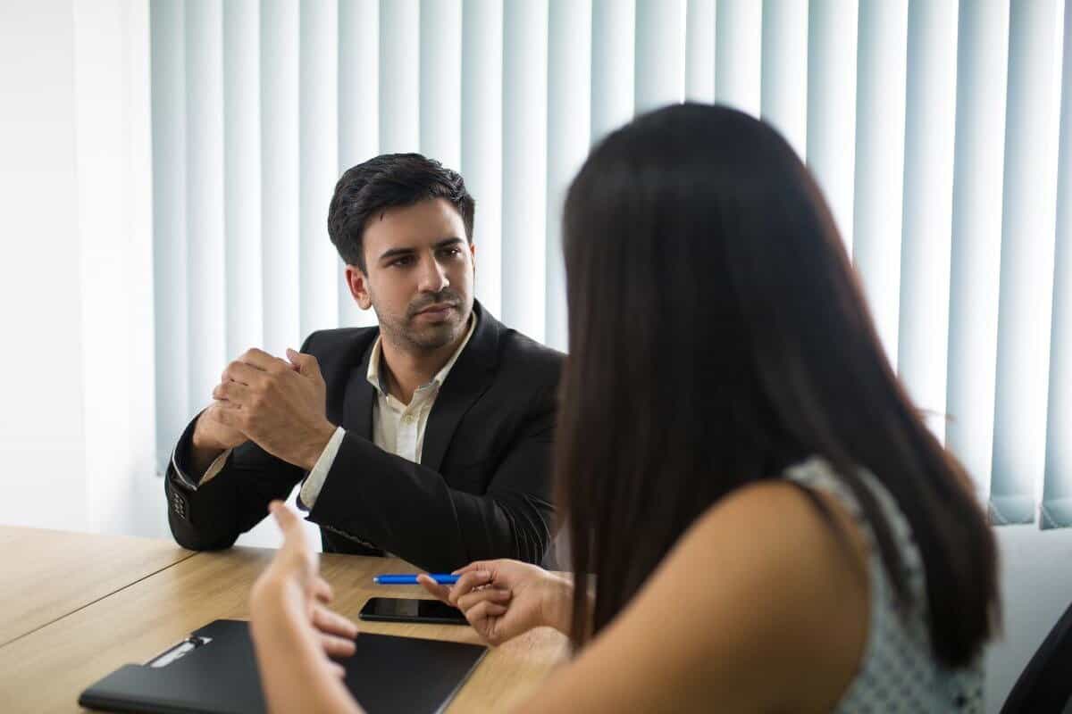 Imagem de banco de imagens de um entrevistador ouvindo atentamente um candidato durante uma entrevista de emprego.