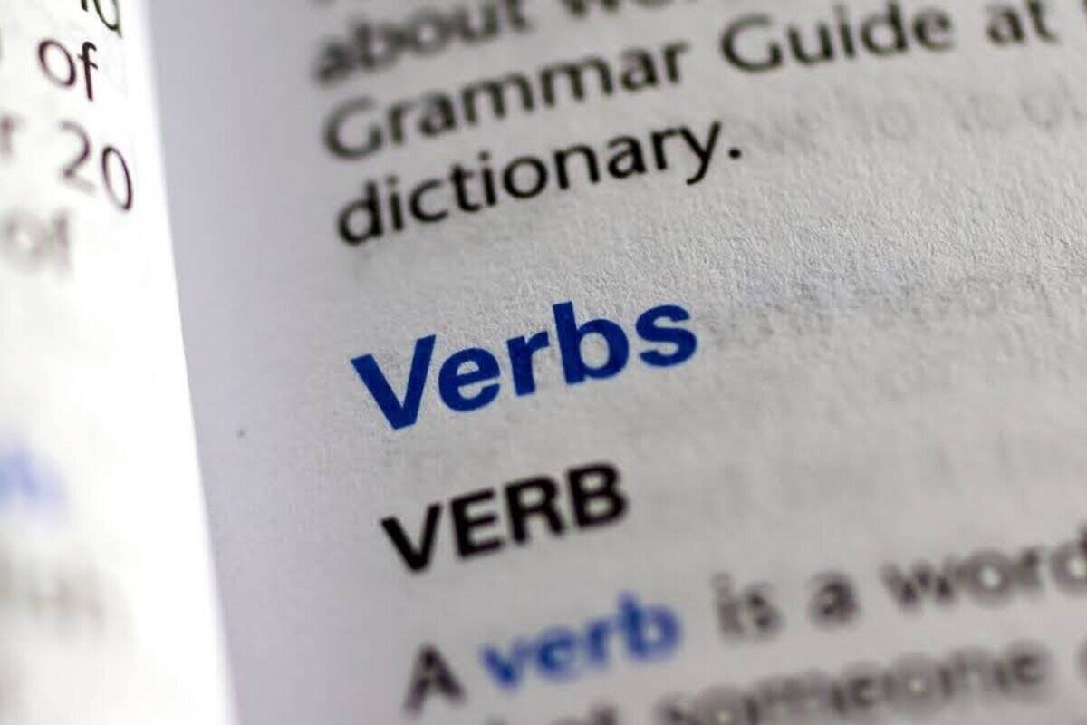Close-up image of the word 'verb' in a dictionary, highlighting its definition and usage in English grammar