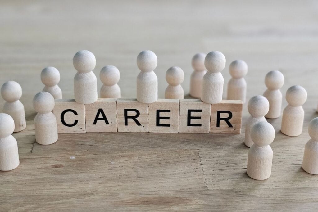People made of wood gather around blocks that spell career
