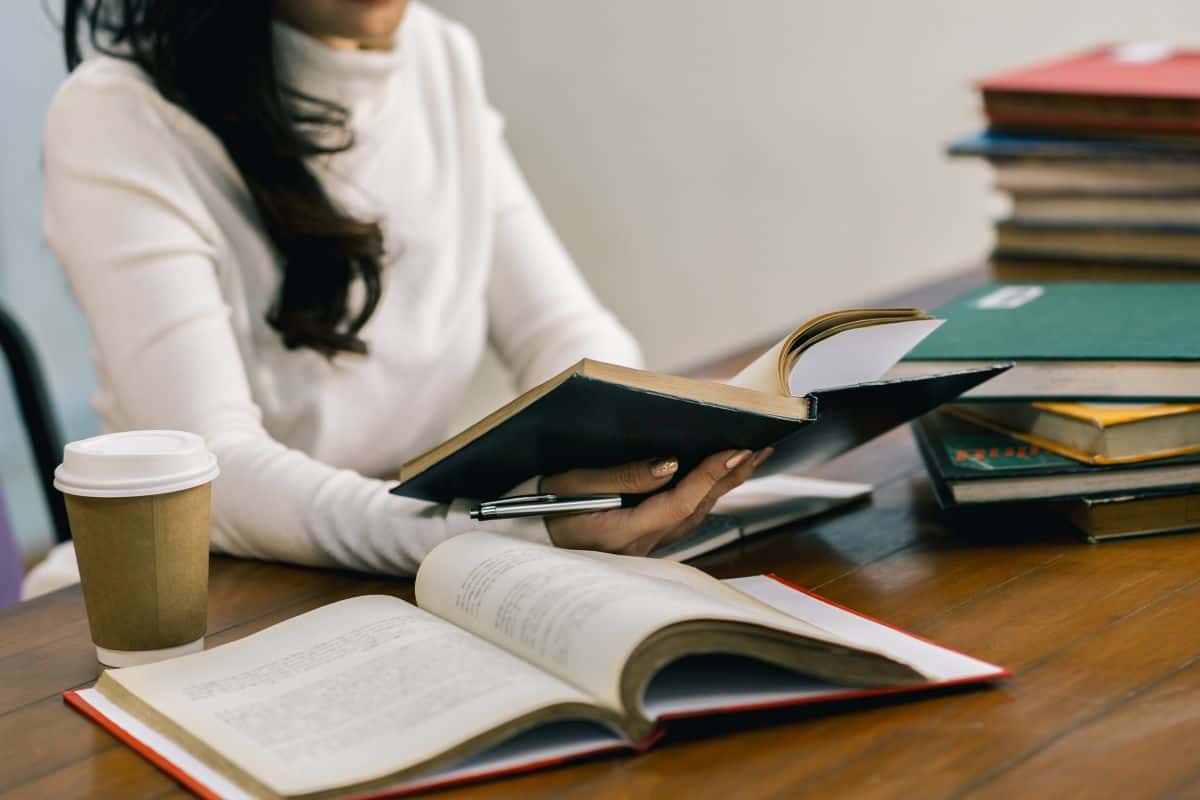 Midsection of woman student at table in library
