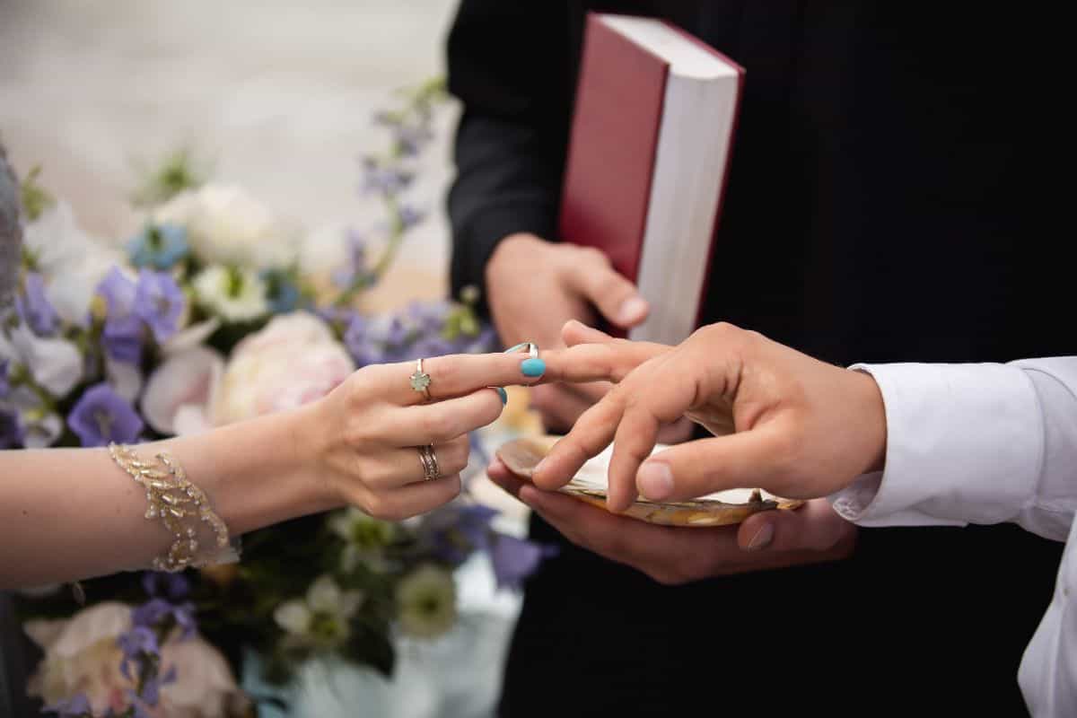 Wedding rings. Hands of bride and groom in solemn process