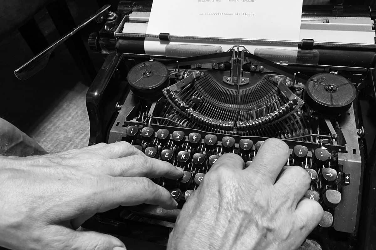 Cropped hands of man using typewriter
