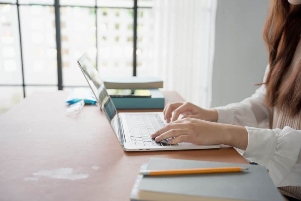 QuillBot Summarizer vale la pena? Recensione completa 6 Asian woman working with laptop in living room