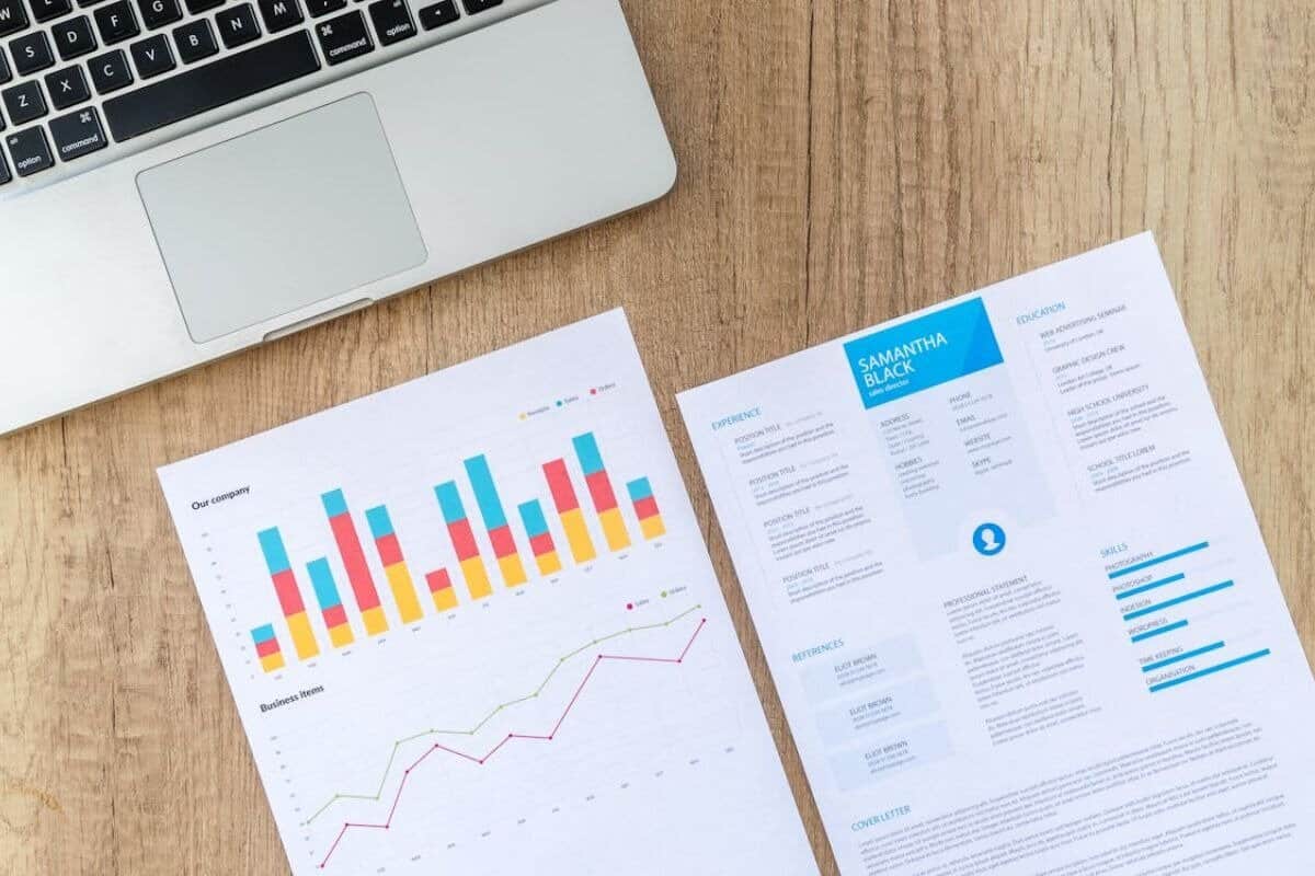 Image displaying an analytics report alongside a printed CV document on a desk