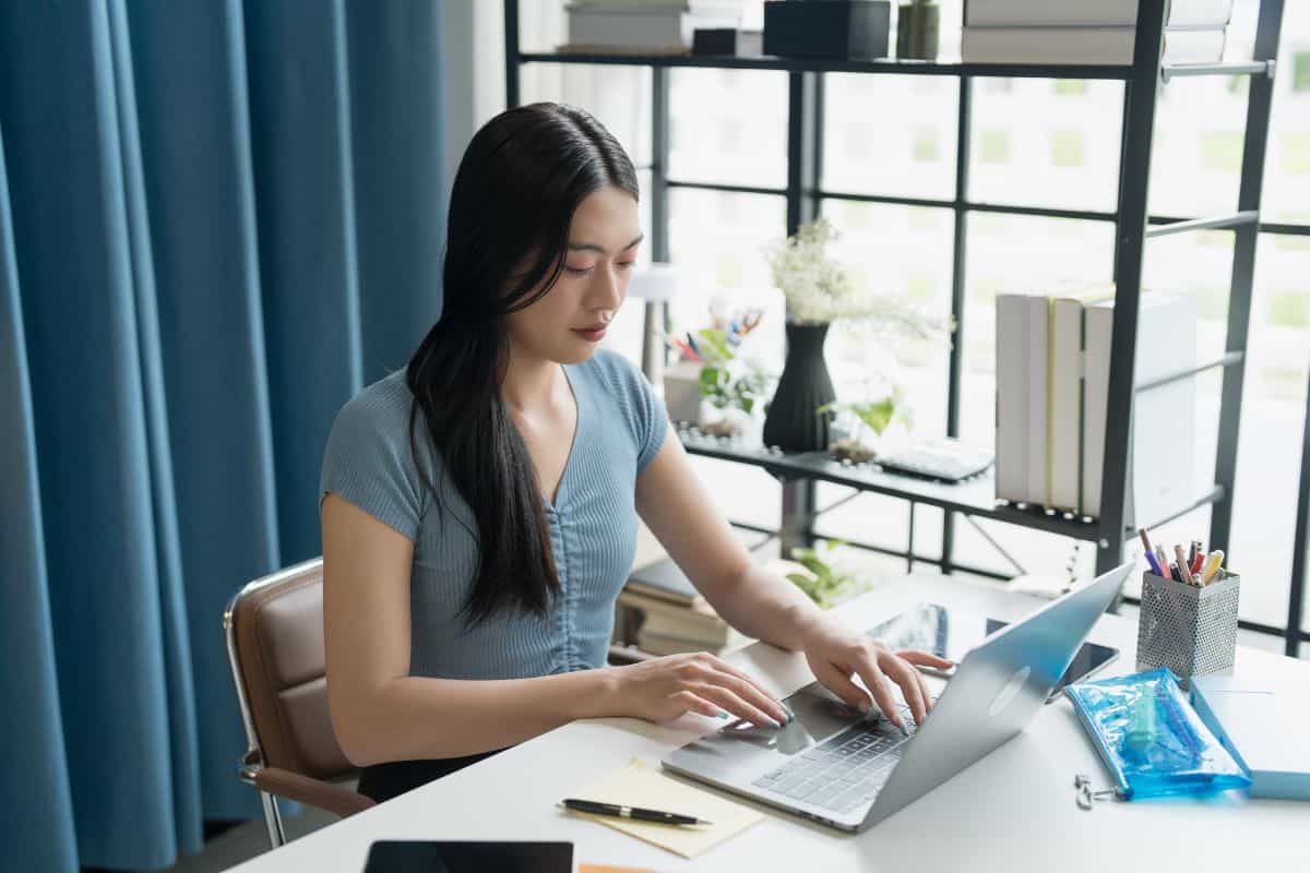 Young asian woman using laptop for work at home