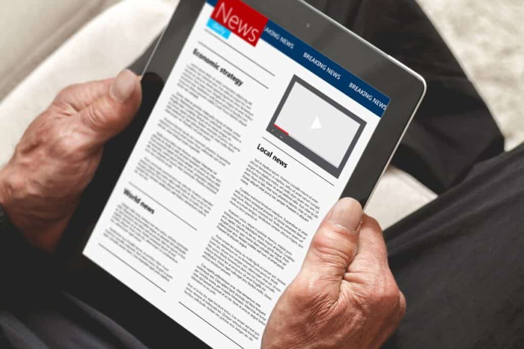 Comment rédiger un article de journal en respectant le format 9 Senior reading news on tablet