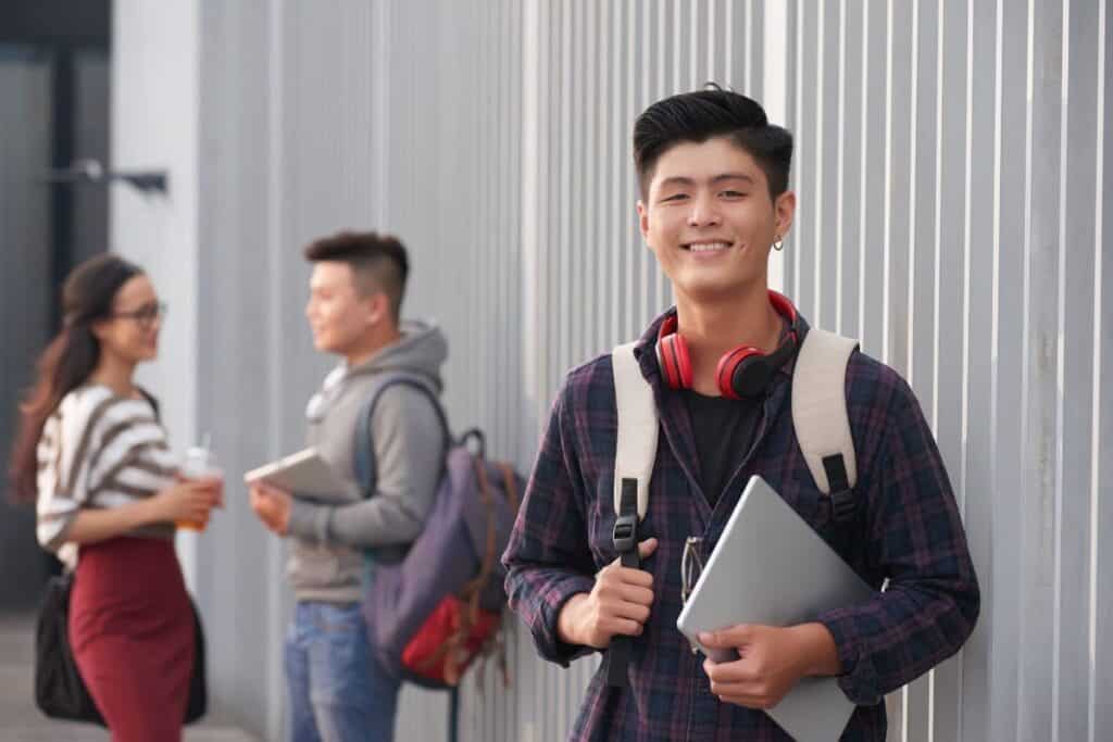 Aggettivo composto: Significato, regole ed esempi 7 Ritratto di studente asiatico sorridente