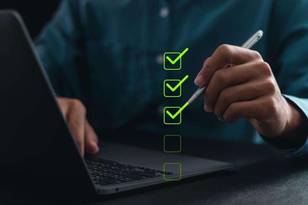 Businessman using laptop and checking mark on checkboxes for checklist