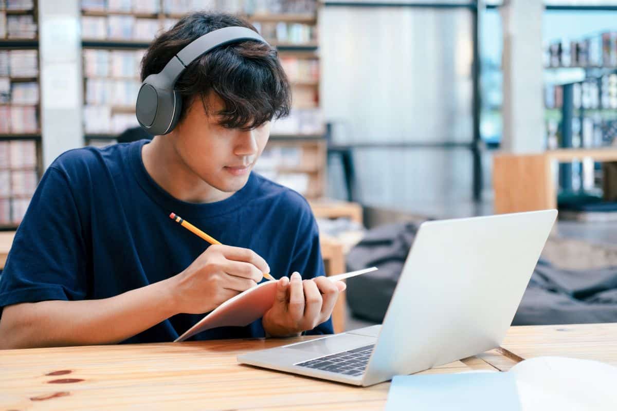 Young collage student using computer and mobile device studying online