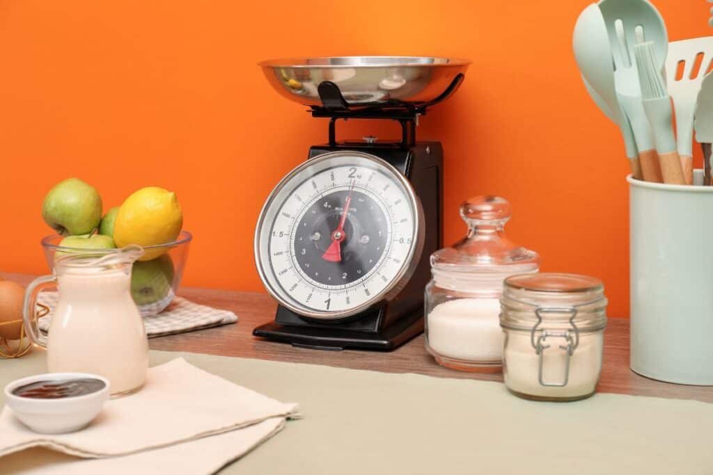 Combien de grammes dans une once ? Réponse rapide 4 Kitchen scale products and cooking utensils on wooden table