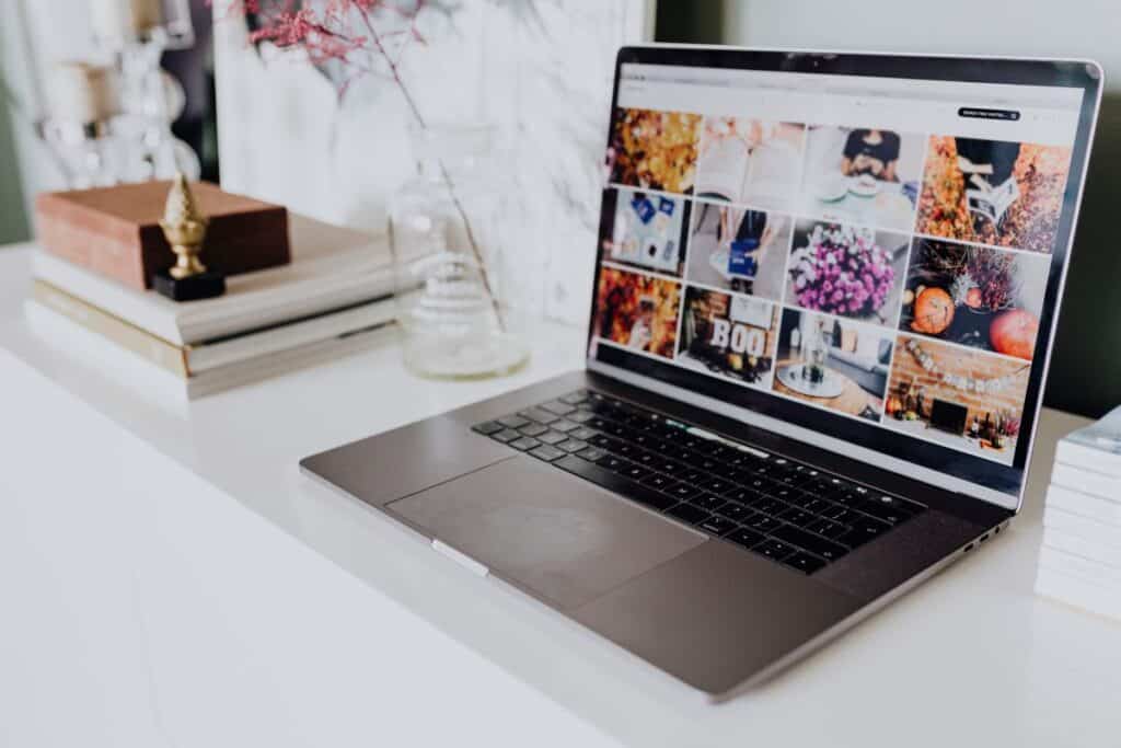 Laptop displaying images on a blog on a white table