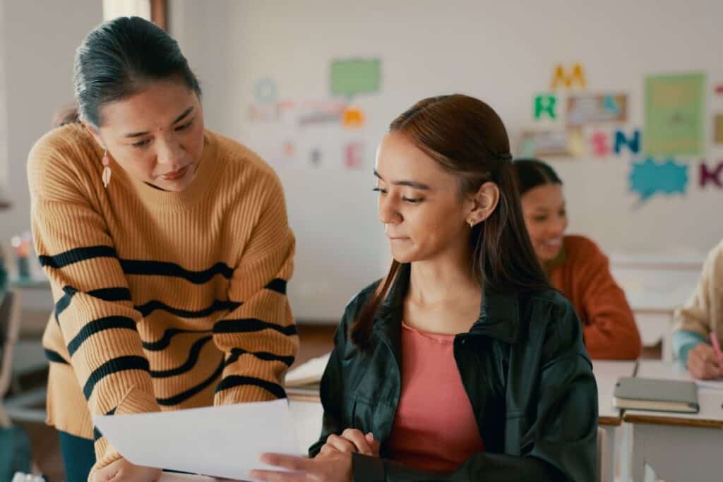 Teacher test and education with girl in classroom