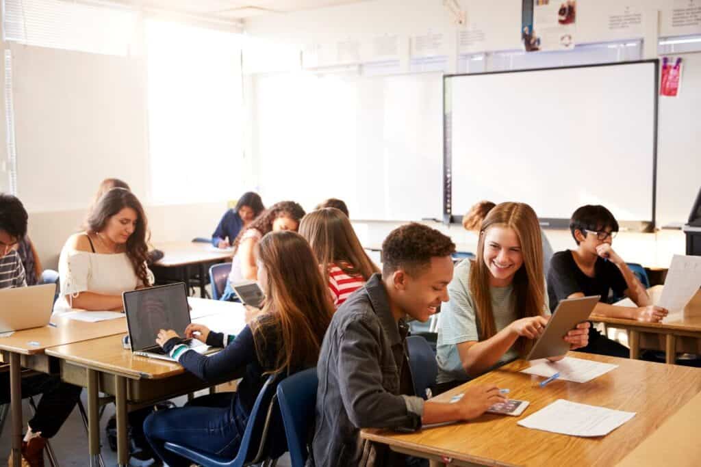 Wide angle view of high school students sitting at desks in classroom