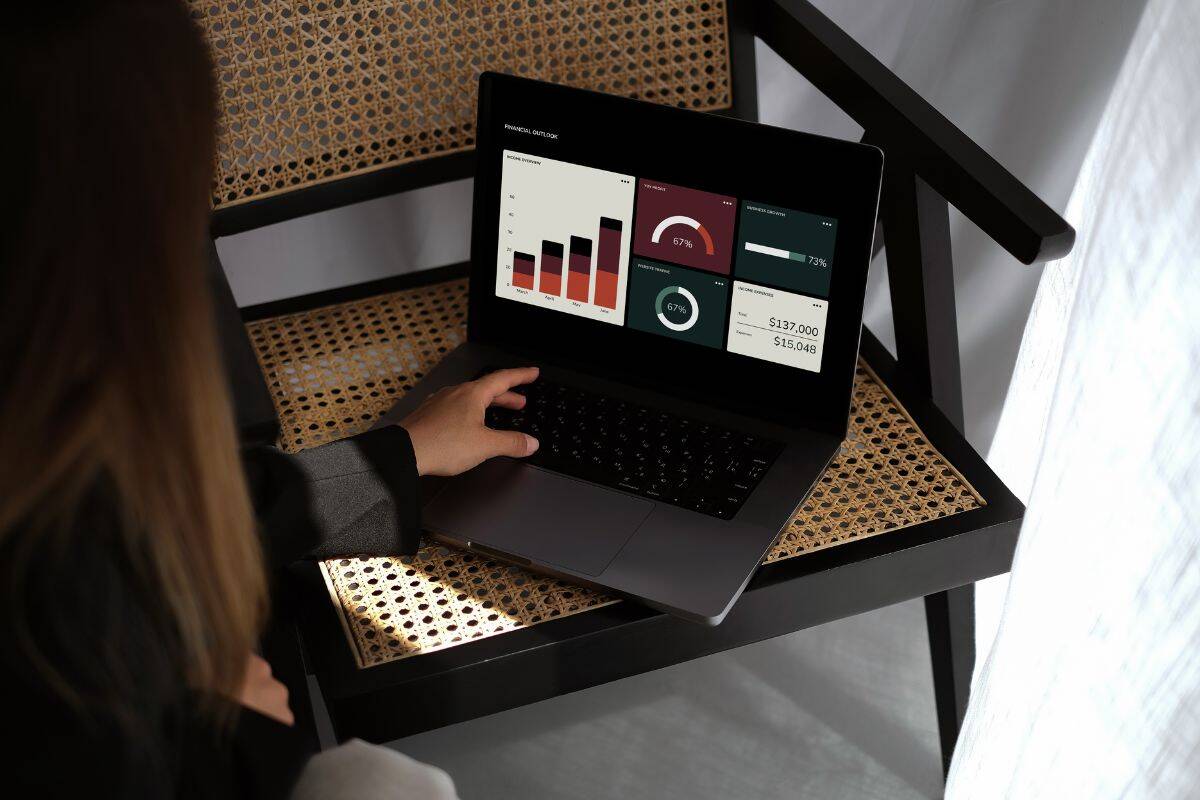 Donna che utilizza un computer portatile e visualizza dati analitici sullo schermo