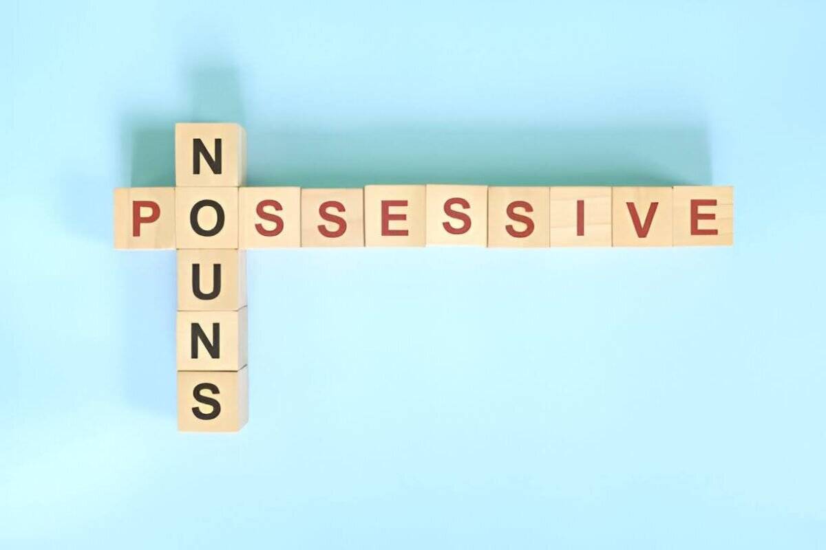 Scrabbled wooden letters spelling possessive noun