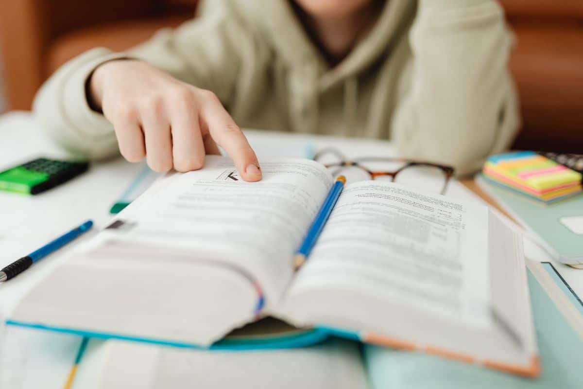 A young man pointing at something in a book