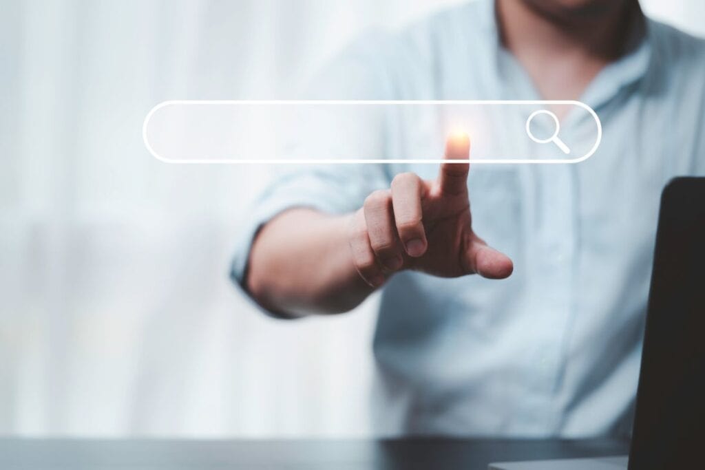 Hand touching with search icon for search engine optimisation 
