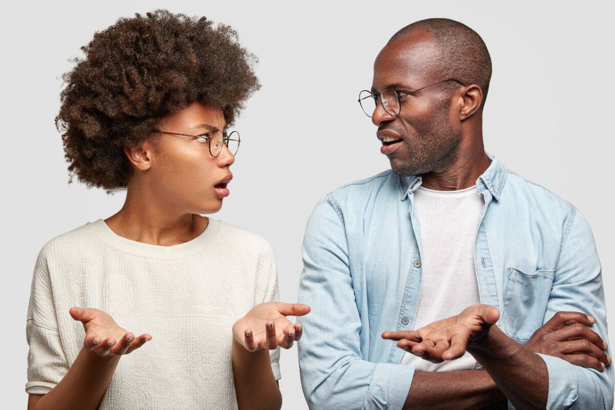 Um casal afro-americano confuso olha um para o outro com raiva