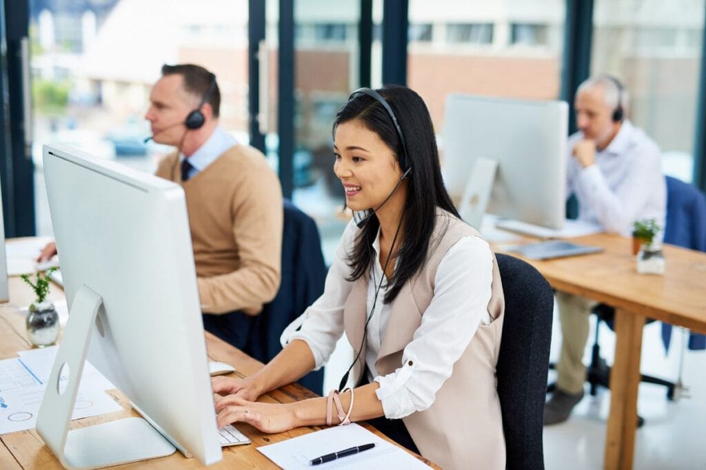 Phone call man and woman at computer at help desk customer