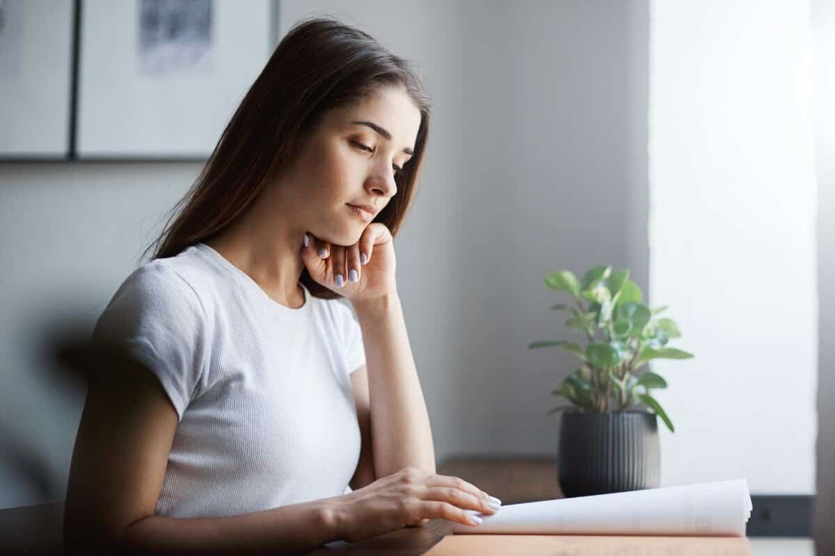 Jeune étudiant anglais apprenant une langue à l'aide d'un cahier d'exercices hors ligne concentré