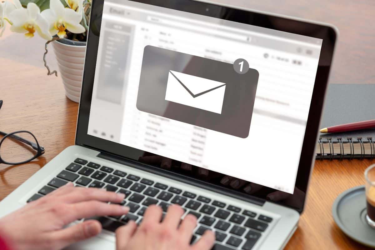 Image de stock d'une personne recevant une notification de courrier électronique sur un ordinateur portable.