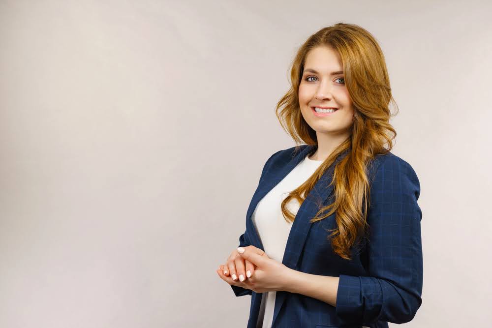 O que é traje profissional de negócios (com exemplos) 8 Mulher de negócios vestindo terno e olhando para a câmera