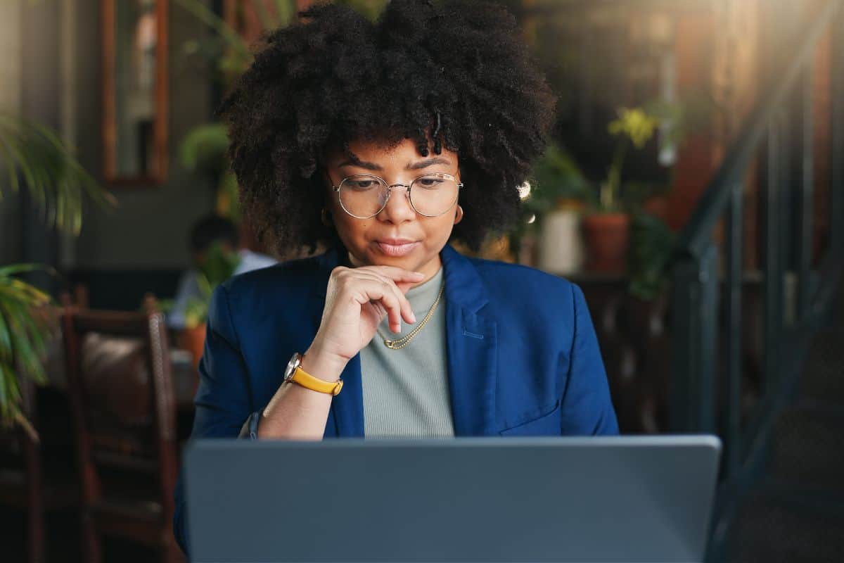 Woman thinking and restaurant with laptop remote work