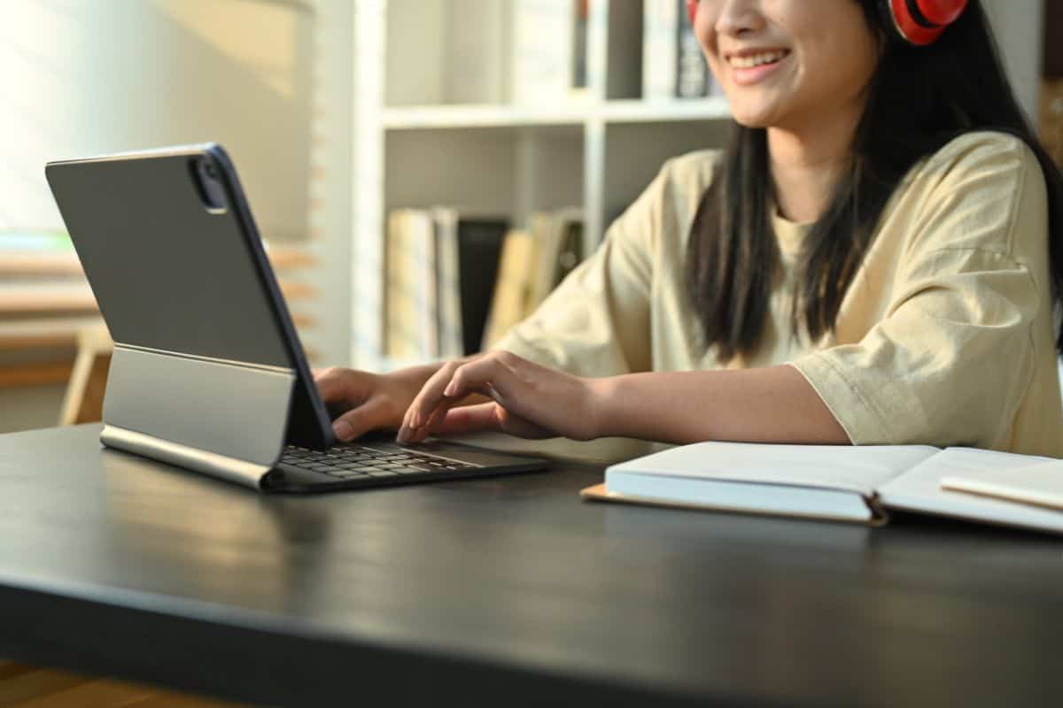 Smiling teenage girl in headphones studying online classes