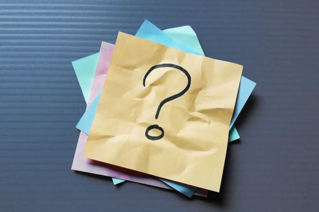 Crumpled note paper with question mark on textured background