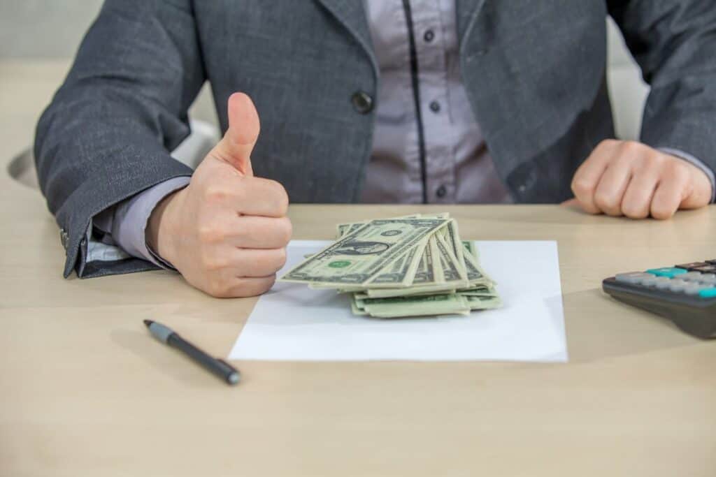 Young businessman working from his office and counting cash money