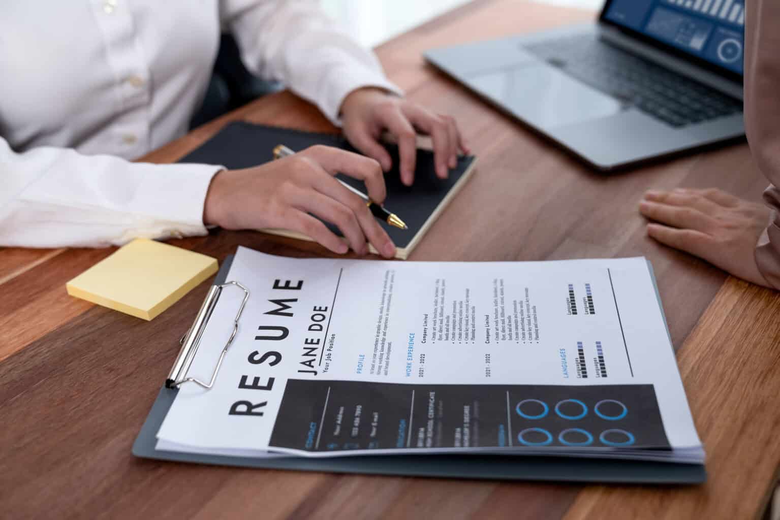 Closeup resume paper with qualifications on desk during interview
