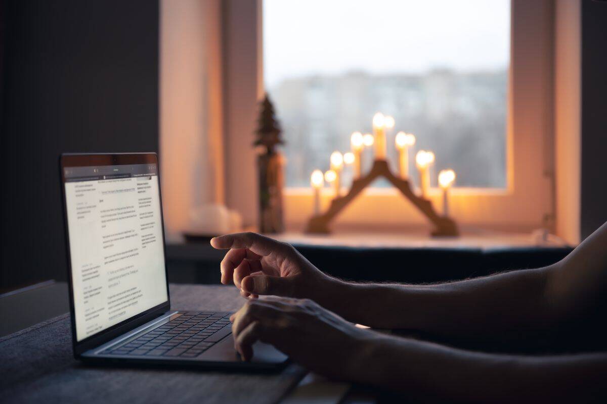 Un uomo legge le notizie seduto di notte davanti allo schermo del laptop