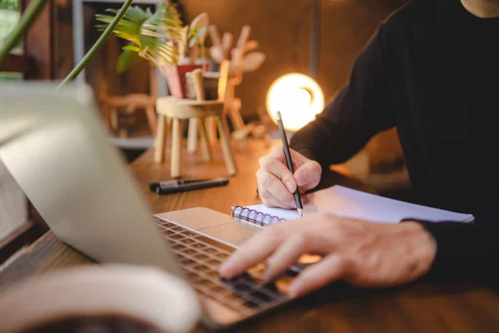 People hand holding a pen for working to write on a book 