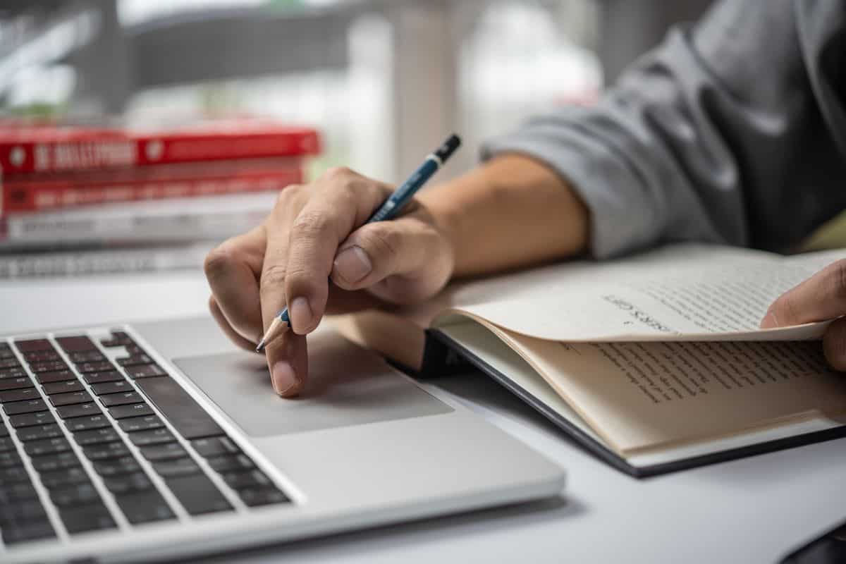 Learning online class by using laptop computer and writing notebook