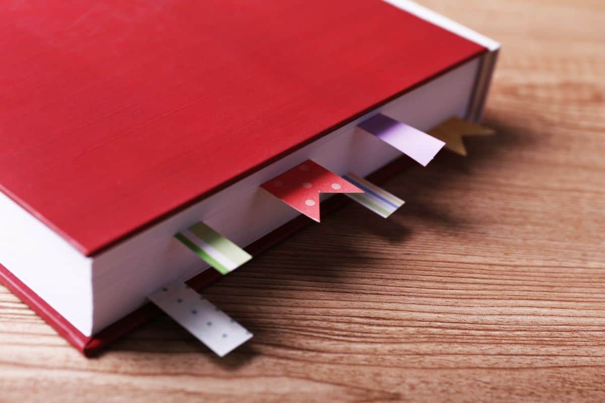 Book with bookmarks on wooden background