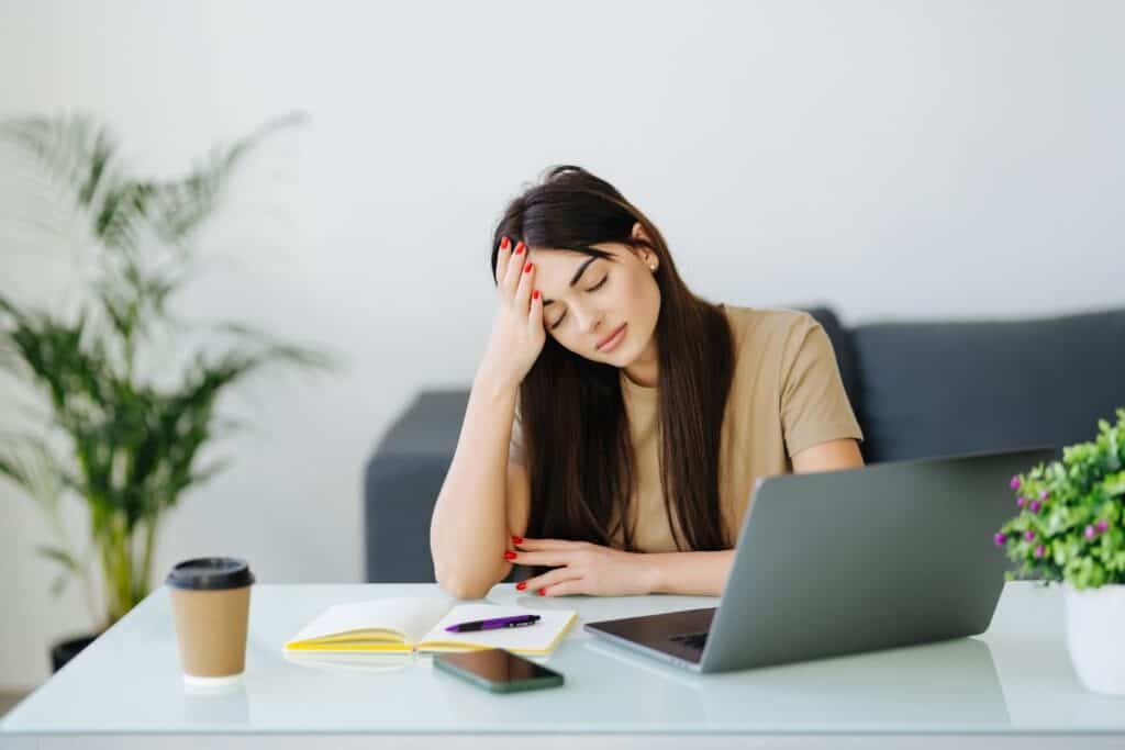 Stressed frustrated young woman student looking at laptop