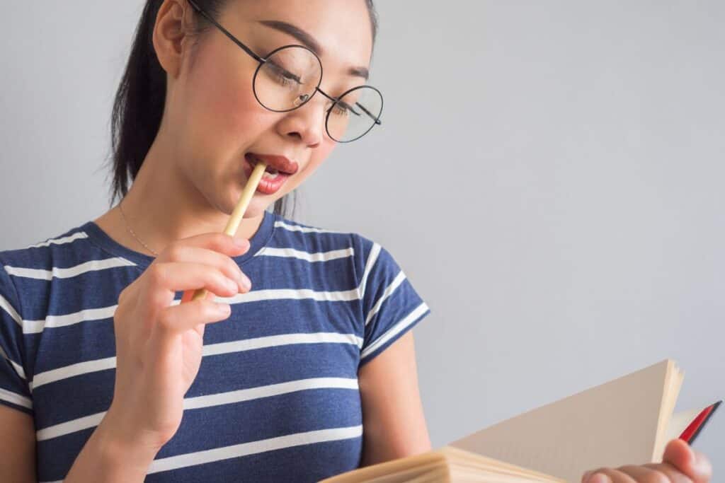 Asian woman reading book and thinking for ideas.