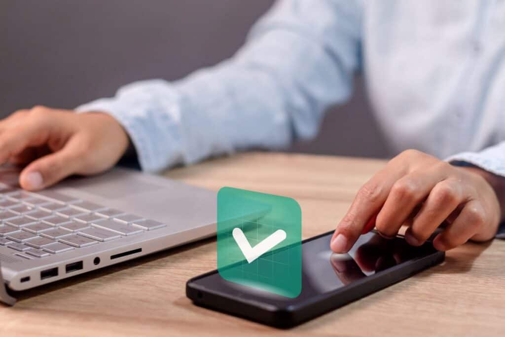 A man using smartphone with green checkmark 