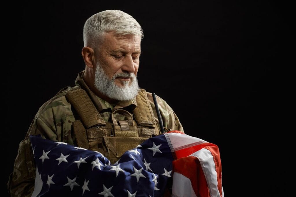 +50 melhores citações sobre o Dia dos Veteranos para inspirar e lembrar 8 militar-veterano segurando a bandeira americana