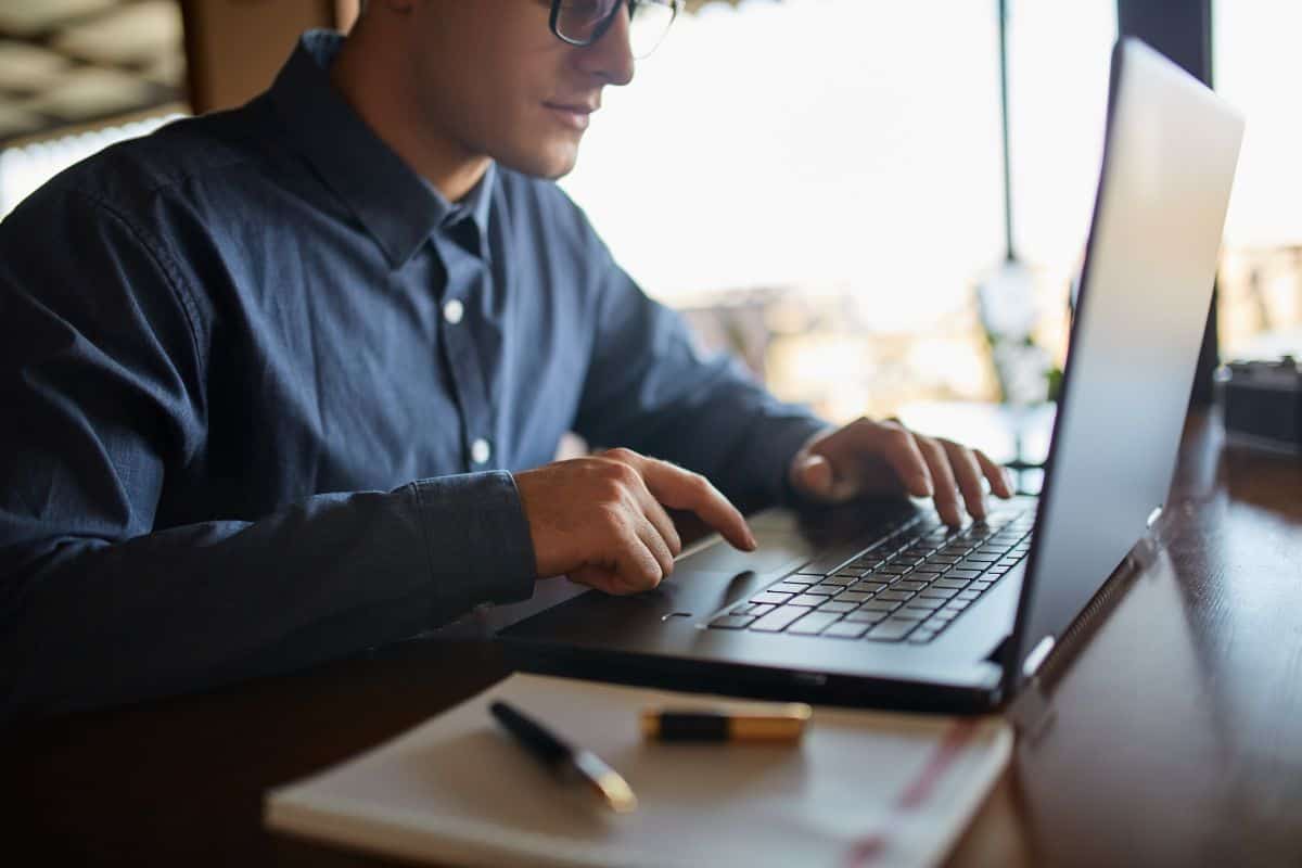 photo of caucasian male hands typing on laptop keyboard
