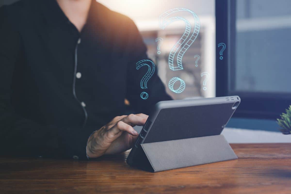 Question mark symbol with hologram on hand of man with tablet